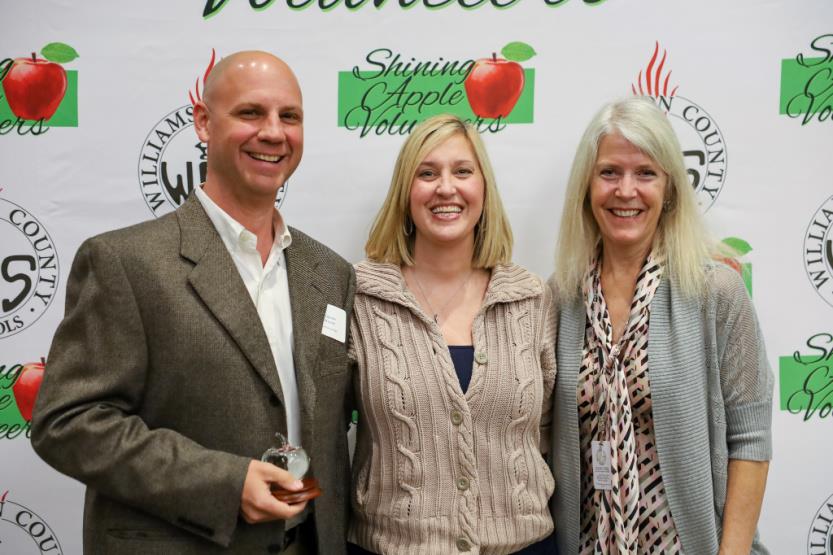 A man and two women pose for a photo